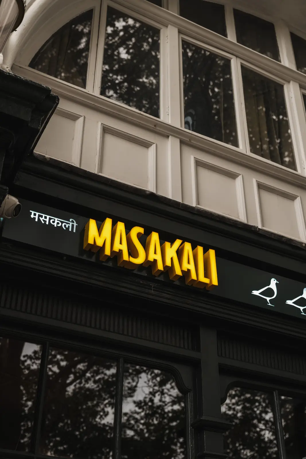 Masakali frontage and window signage in the evening