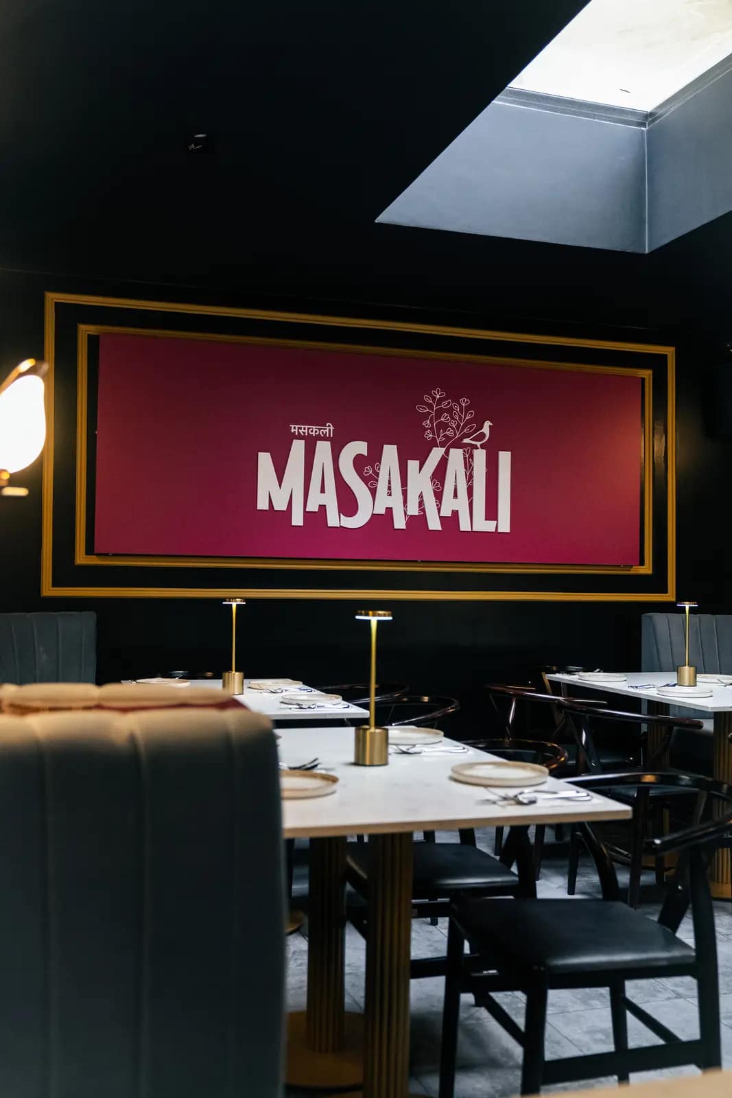 Tables beneath the crimson Masakali sign